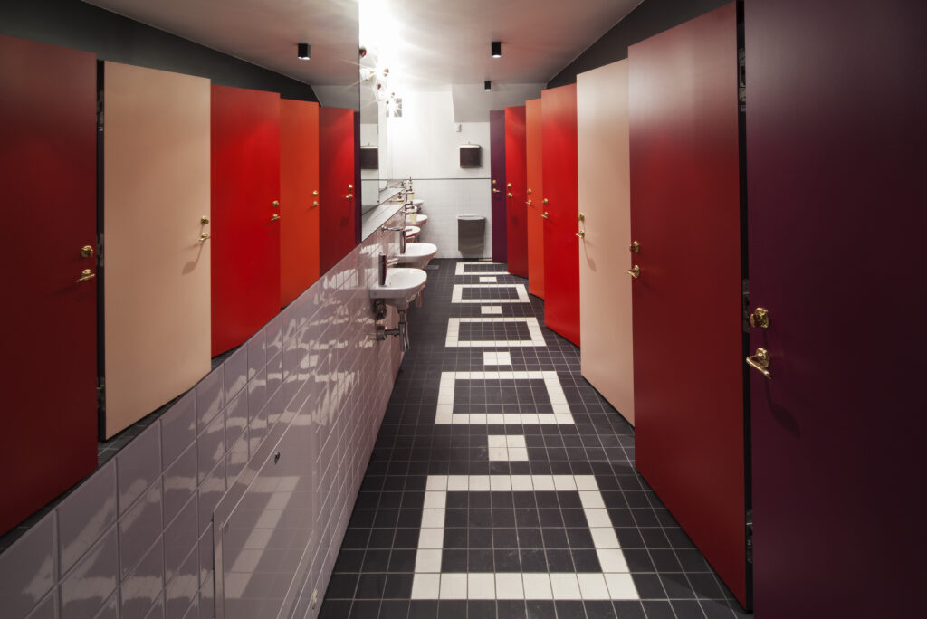 Toaletter med dörrar i olika nyanser av rött.