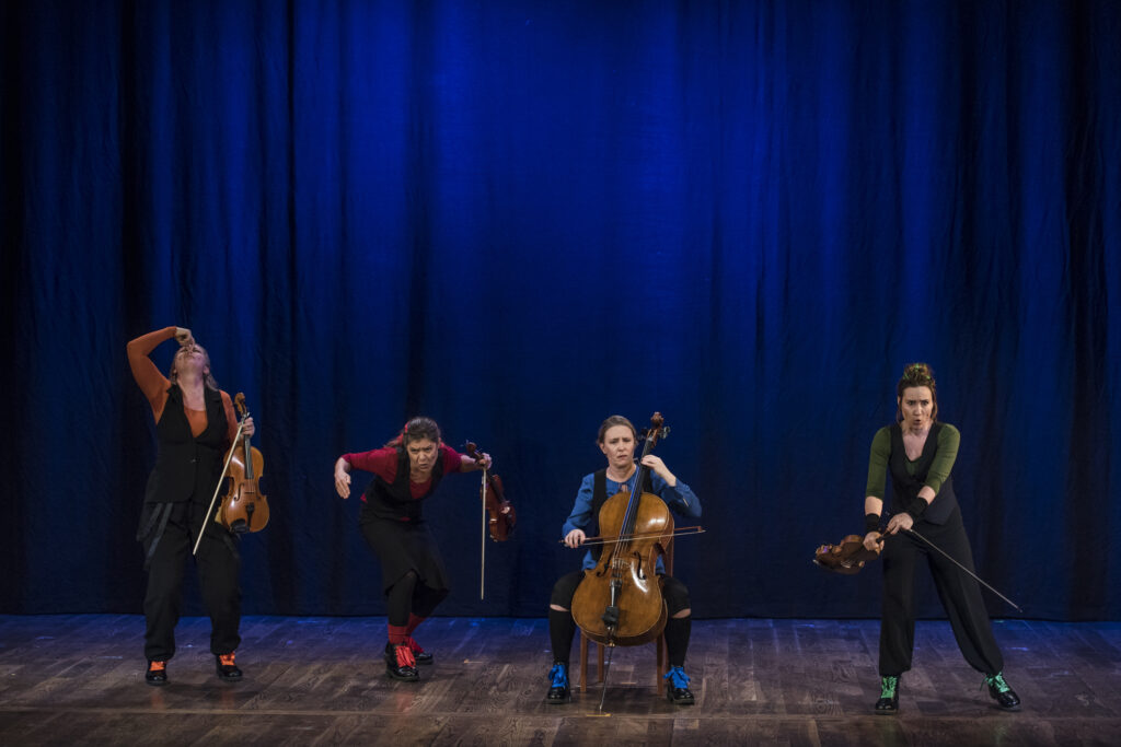 Fyra kvinnor uppträder med varsitt stråkinstrument.