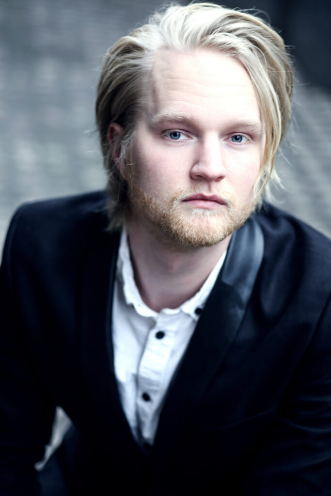 Porträttfoto av sångaren Wiktor Sundqvist klädd i kavaj.