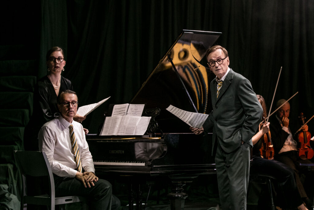 Bild på en pianist, en sångerska och en skådespelare vid ett piano.